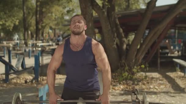 Culturista masculino haciendo ejercicio con barbell al aire libre — Vídeos de Stock