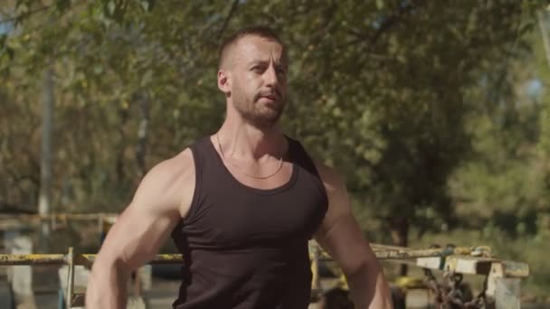 Muscular hombre haciendo dumbbell hombro volar al aire libre — Vídeos de Stock