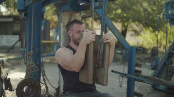 Homem forte que flexiona músculos na máquina da imprensa do peito — Vídeo de Stock