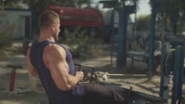 Spor salonunda oturan düşük kablolu kasnak satır yapma Atlet