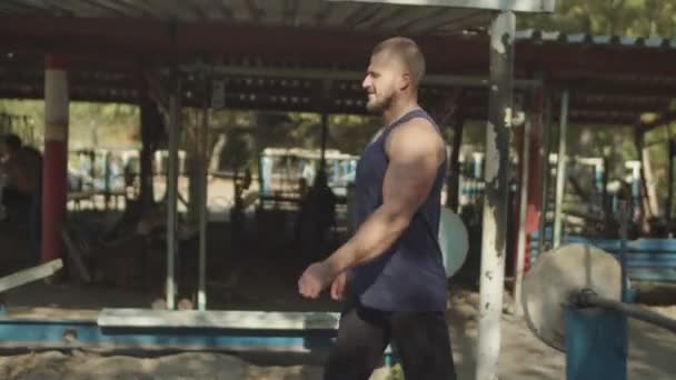 Hombre fuerte calentando los brazos antes de hacer ejercicio al aire libre — Vídeos de Stock
