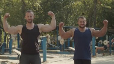 Neşeli bodybuilders çift pazı poz gösteren
