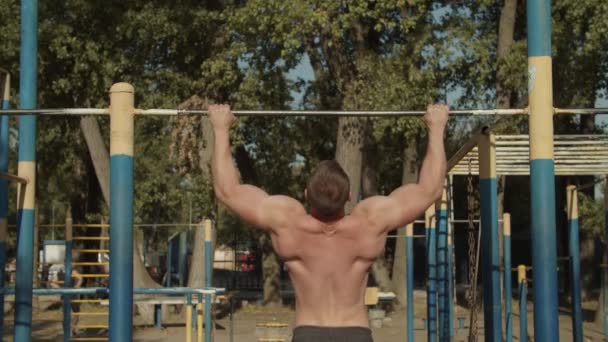 Hombre atlético haciendo ejercicios pull-up en el travesaño — Vídeo de stock