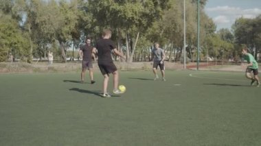 Genç futbolcu sahada topa tekme atıyor