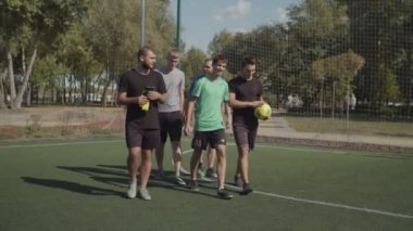 Neşeli futbolcular futbol sahasına yürümek