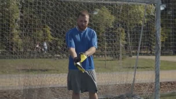 Confident soccer goalkeeper adjusting gloves — Stock Video