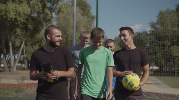 Футболисты готовятся играть в футбол на открытом воздухе — стоковое видео