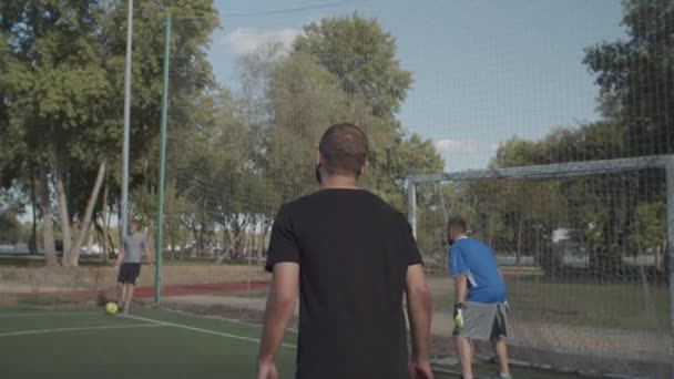 Fotbollsspelare rubrik bollen att göra mål på pitch — Stockvideo