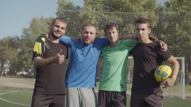 Pozitivní jednotný fotbalový tým pózující na hřišti — Stock video