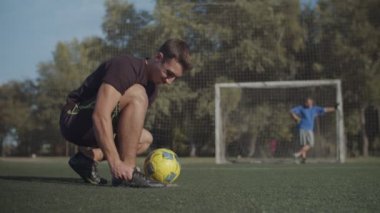 Futbolcu ayakkabı bağlama oyununa hazırlanıyor