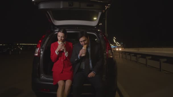 Casal em viagem de carro desfrutando de fast food à noite — Vídeo de Stock