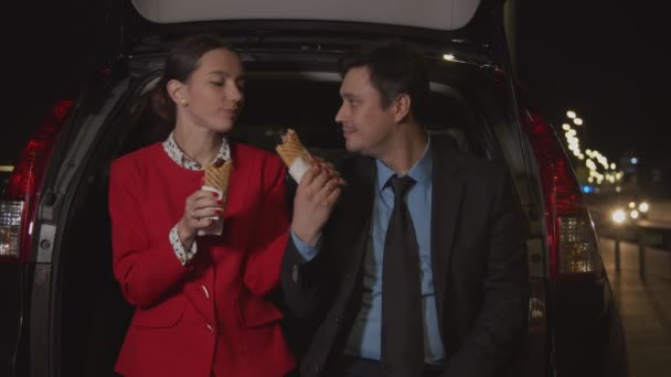 Affärskollegor delar måltid i bil på natten — Stockvideo