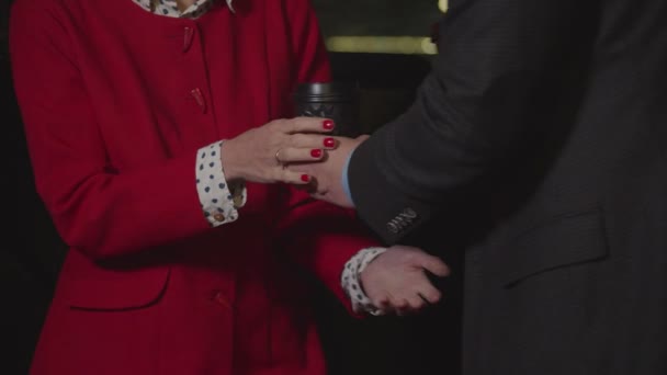 Male hand giving takeaway coffee to woman at night — 비디오