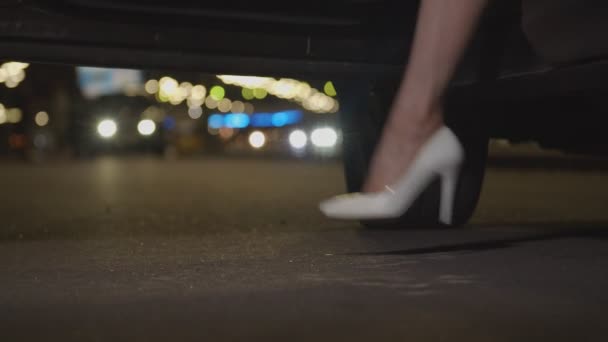 Slim ženské nohy v vysoké podpatky výjezd auto v noci — Stock video