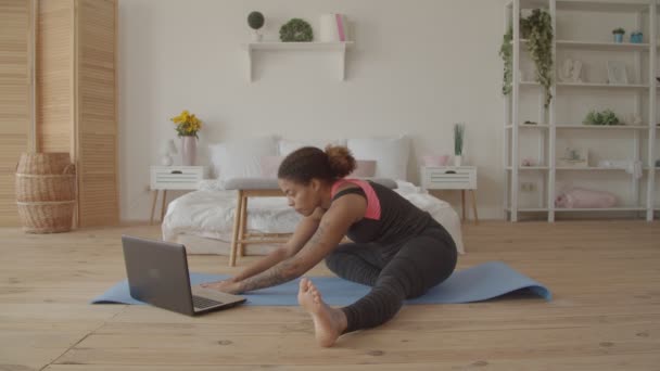 Vrouw die fitness video op laptop bekijkt — Stockvideo