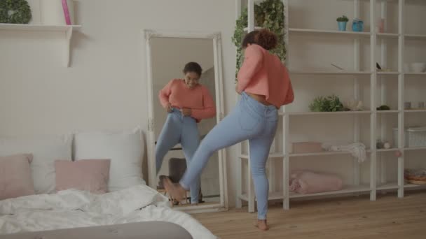 Afrikaanse vrouw probeert te knijpen in strakke jeans — Stockvideo