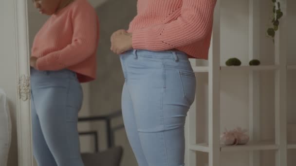 Weight gain woman buttoning pants with difficulties — Stockvideo