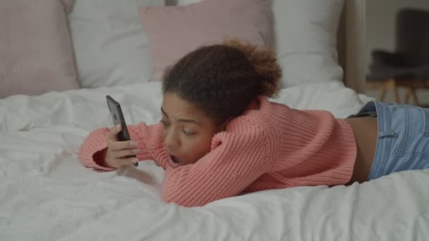 Vrolijke Afrikaanse vrouw aan de telefoon in de slaapkamer — Stockvideo
