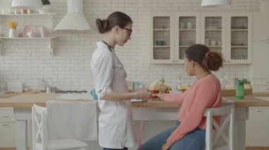 Konsültasyon sırasında hastaların belini ölçen beslenme uzmanı