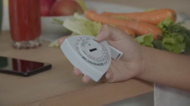 Kapalı alanda bmi hesap makinesi tutan kadın el.