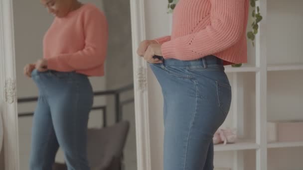 Donna felice in vecchi jeans sciolti dopo aver perso peso — Video Stock