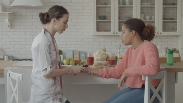 Médico femenino revisando el pulso de paciente preocupado — Vídeo de stock