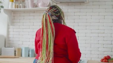Güzel Afrikalı kadın yemek yaparken eğleniyor.