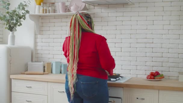 Cooking joyful black female dancing in kitchen — Stock Video