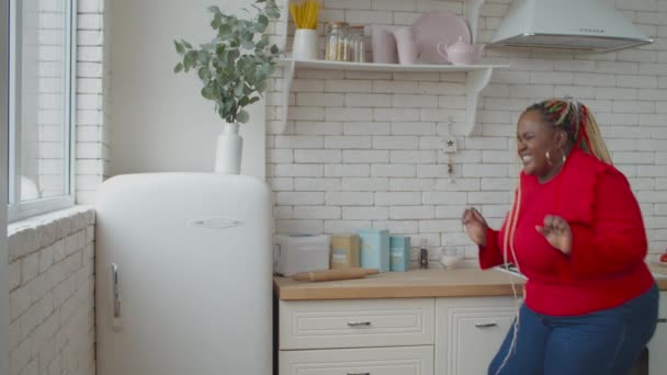 Mujer africana con sobrepeso atrapada cerca del refrigerador — Vídeos de Stock