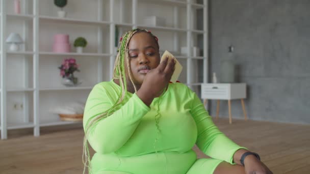 Уставшая толстая женщина вытирает пот после тренировки — стоковое видео