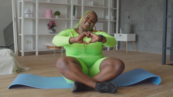 Весела жінка з надмірною вагою, що показує форму серця — стокове відео