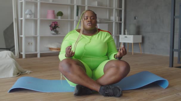 Yogi mollige Afrikanerin meditiert in Lotus-Pose — Stockvideo