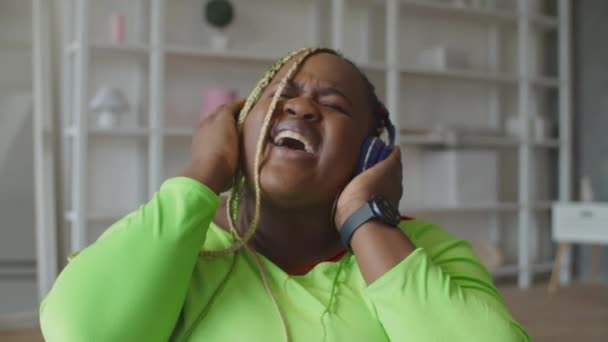 Preciosa mujer africana escuchando música en auriculares — Vídeos de Stock