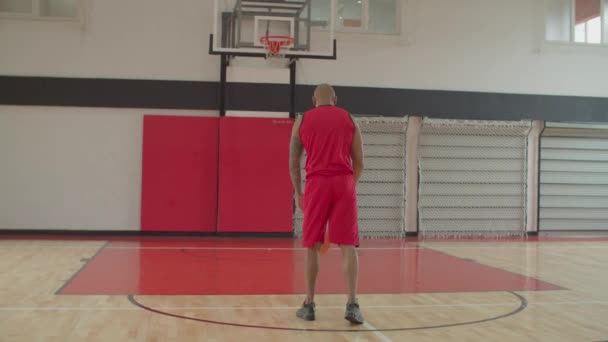 African basketball player taking free throw indoor — Stock Video