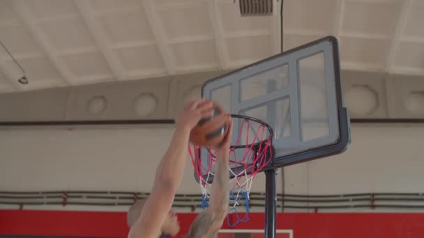 Jugador de baloncesto haciendo volcado inverso en el juego — Vídeo de stock