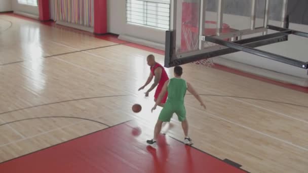 Dua pemain basket bermain di lapangan dalam ruangan. — Stok Video