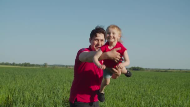 Zorgzame vader vliegen schattig kind op handen in de natuur — Stockvideo