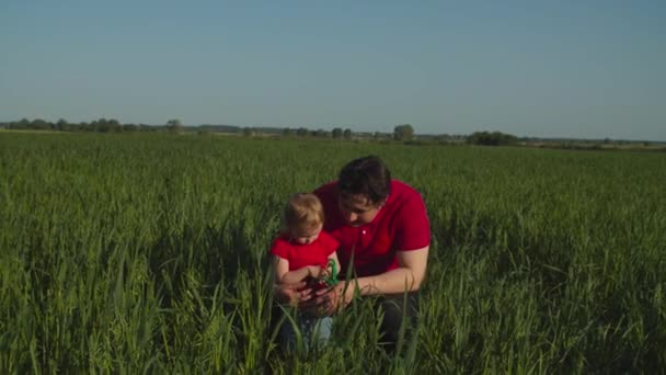 Заботливый отец показывает ребенку что-то в природе — стоковое видео