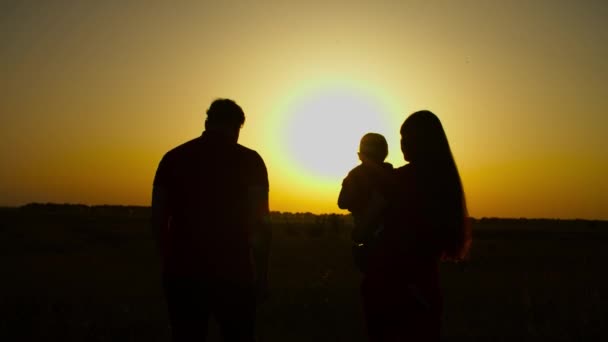 Família unida com bebê menina andando ao pôr do sol — Vídeo de Stock