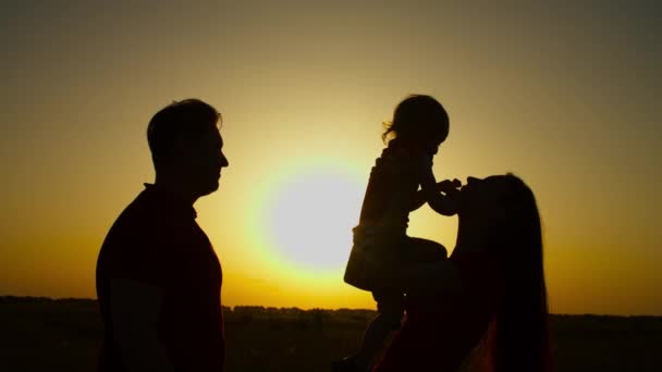 Família amorosa com criança desfrutando de lazer ao pôr do sol — Vídeo de Stock