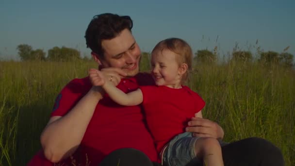 Padre y niño pequeño que se relaja en la naturaleza — Vídeos de Stock