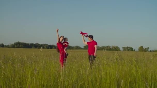 Familia con bebé jugando con avión modelo en la naturaleza — Vídeos de Stock