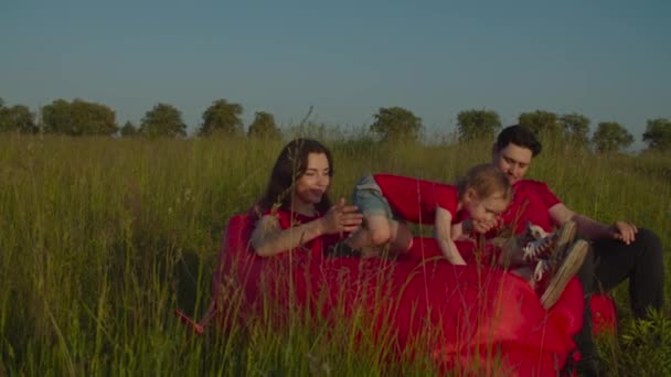 Безтурботна сім'я з дитиною насолоджується відпочинком на відкритому повітрі — стокове відео