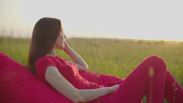 Tranquil bonita mujer en beanbag relajarse en la naturaleza — Vídeos de Stock