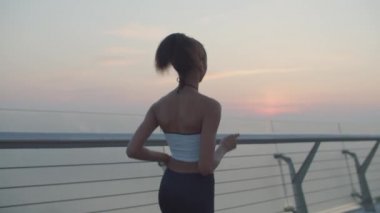 Sabah parıltısıyla koşan sporcu kadının arka manzarası