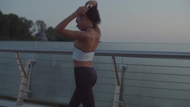 Atletische vrouw opwarmen spieren voor joggen — Stockvideo