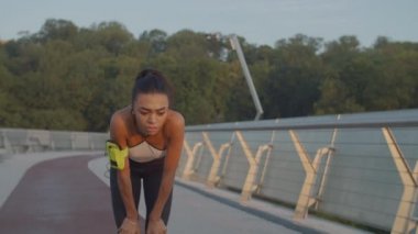 Yorgun kadın koşucu koşudan sonra soluklanıyor.