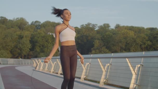 Mujer negra haciendo ejercicio con saltar la cuerda al aire libre — Vídeos de Stock