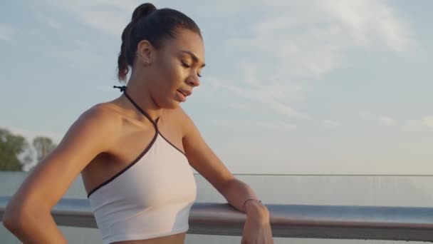 Trött afrikansk kvinnlig joggare tar en paus utomhus — Stockvideo