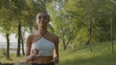 Koşan kadın şehir parkında kardiyo çalışması yapıyor.